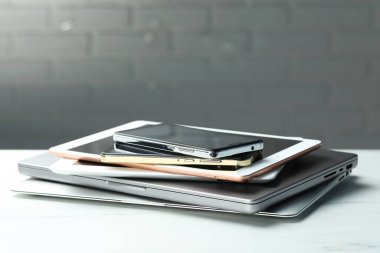 Elektronik cihazların yığını beyaz masada, yakın plan. Metin için boşluk