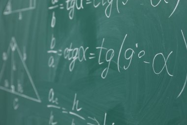 Tahtaya birçok farklı matematik formülü yazılmış.