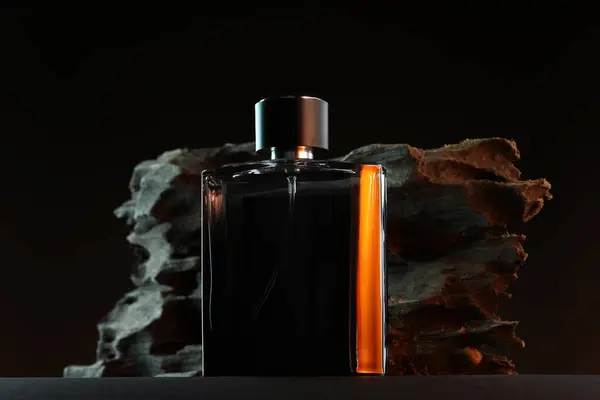 stock image Luxury men`s perfume in bottle on grey table against dark background