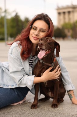 Woman with her cute German Shorthaired Pointer dog outdoors