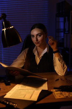 Geceleri ofiste belgelerle çalışan profesyonel dedektif.