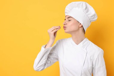 Professional chef showing perfect sign on yellow background. Space for text