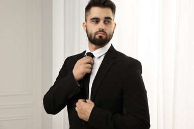 Handsome businessman in suit and necktie indoors