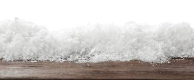 Beyaz arka plana karşı tahta yüzeyde kar. Noel sezonu