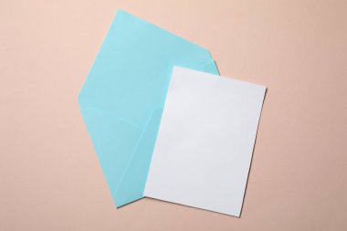 Bej arka planda mektup zarfı ve kart, üst manzara. Metin için boşluk