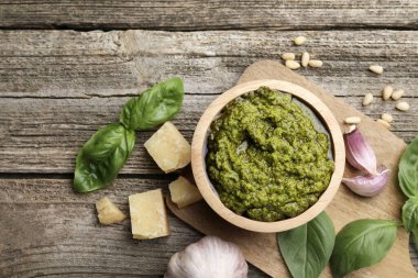 Lezzetli pesto sosu, fesleğen, çam fıstığı, peynir ve sarımsak ahşap masada.