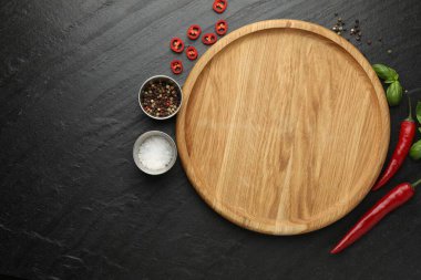 Kesme tahtası, tuz, baharat, fesleğen ve kırmızı biber siyah desenli masa, düz yatak. Metin için boşluk