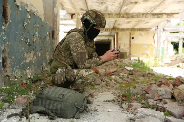 stock image Military mission. Soldier in uniform with drone controller inside abandoned building