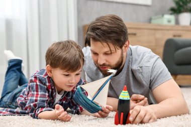 Dad and son playing toys together at home