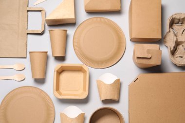 Açık gri arka planda çevre dostu gıda paketleriyle düz kompozisyon