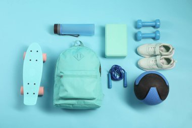 Açık mavi arka planda farklı spor ekipmanları, düz yatış