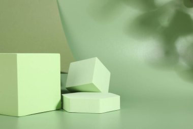 Ürünün sunumu. Yeşil arka planda podyumlar ve gölgeler. Metin için boşluk