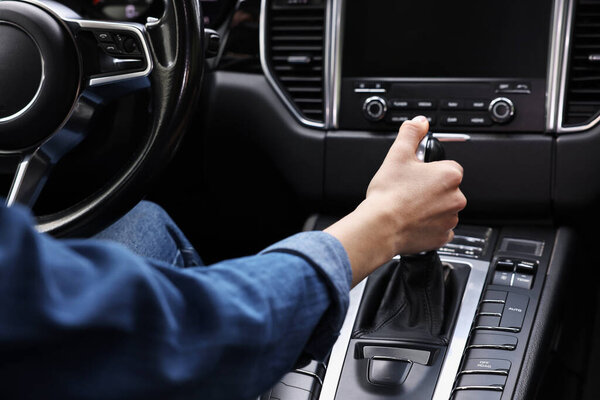 Женщина с палкой передач за рулём машины, крупным планом