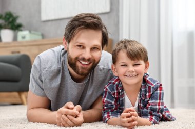 Family portrait of happy dad and son at home