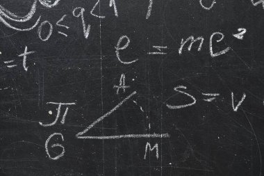 Tahtaya tebeşirle yazılmış birçok fiziksel formül.
