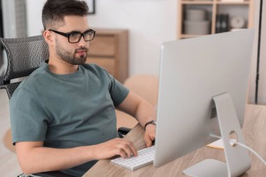 Ofisteki masada bilgisayarla çalışan programcı