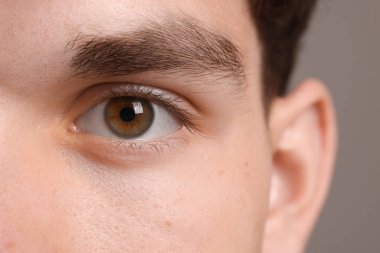 Man with beautiful eyes on grey background, closeup