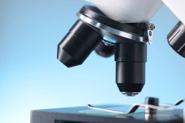 Açık mavi arkaplanda modern mikroskop, yakın plan görünümü