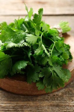 Ahşap masada taze kişniş demeti, yakın plan.