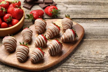 Delicious chocolate covered strawberries on wooden table. Space for text