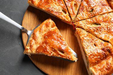 Lezzetli ev yapımı turtayı ve sunucuyu siyah masada kes.