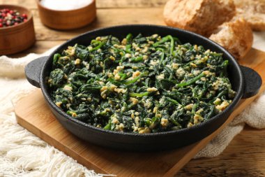 Tahta masada servis edilen lezzetli ıspanak sosu ve yumurta, yakından.