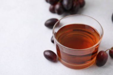 Cam kasede şarap sirkesi ve açık gri masada üzümler, yakın plan. Metin için boşluk