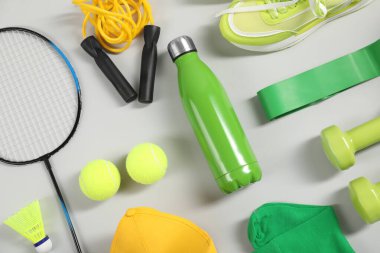 Açık gri arka planda farklı spor ekipmanları, düz yatış
