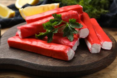 Lezzetli yengeç çubukları ve maydanoz masada, yakın plan.