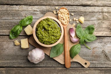 Lezzetli pesto sosu, fesleğen, çam fıstığı, peynir ve sarımsak ahşap masada.
