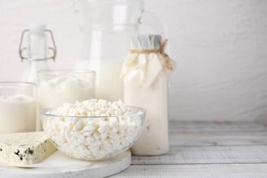 Beyaz ahşap masada farklı taze süt ürünleri.