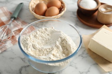 Kısa hamur işi yapıyorum. Hamur için farklı malzemeler ve beyaz mermer masa üzerinde çırpma