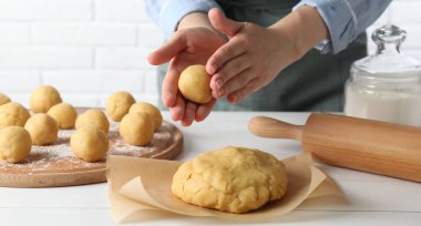 Shortcrust pastry. Woman making dough ball at white wooden table, closeup