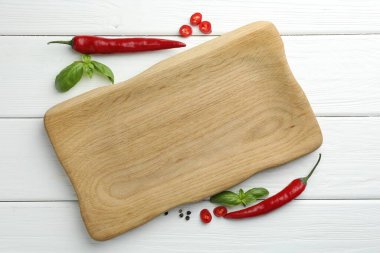 Kesme tahtası ve beyaz ahşap masada farklı baharatlar.