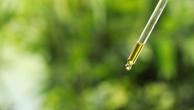 Pipetten gerekli yağı damlatıyor, yakın plan. Metin için boşluk