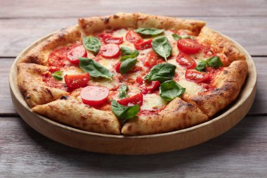 Lezzetli Margherita pizzası ahşap masada, yakın plan.