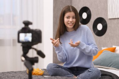 Smiling teenage blogger explaining something while streaming at home