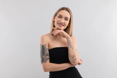 Açık arkaplanda dövmeli güzel bir kadının portresi.