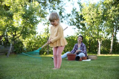 Mother and her daughter working together in garden