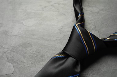 Gri desenli masaya çizgili bir kravat, yakın plan. Metin için boşluk