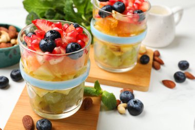 Lezzetli meyve salatası, taze böğürtlen, nane ve fındık beyaz mermer masada.