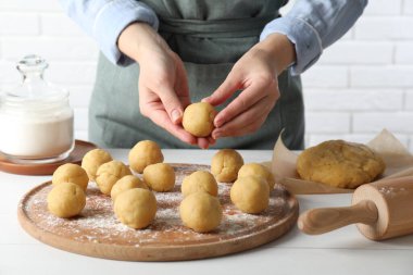 Shortcrust pastry. Woman making dough ball at white wooden table, closeup