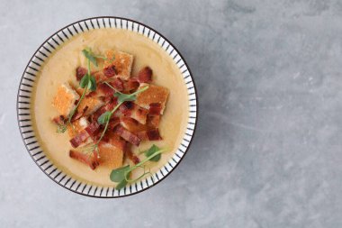 Pastırmalı leziz mercimek çorbası ve gri masadaki mikro yeşillikler. Metin için boşluk