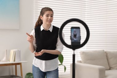 Teenage blogger explaining something while streaming at home