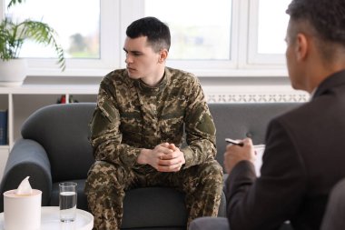 Professional psychotherapist working with military man in office