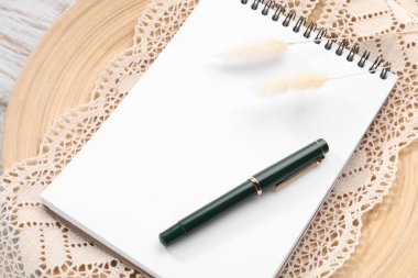 Guest list. Notebook, pen, spikelets and lace ribbon on wooden board, above view