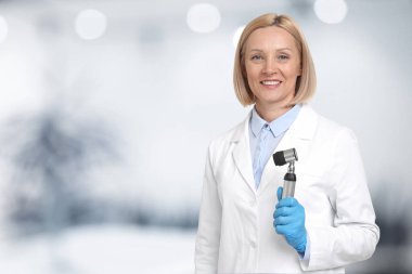 Professional dermatologist with dermatoscope on blurred background, space for text clipart