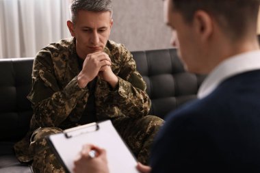 Professional psychotherapist working with military man in office