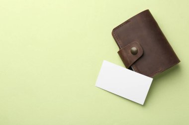 Deri kartvizit sahibi, açık yeşil arka planda, üst manzaralı. Metin için boşluk