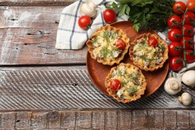 Peynirli, domatesli, mantarlı ve ahşap kırsal masada dereotlu tartlar. Metin için boşluk